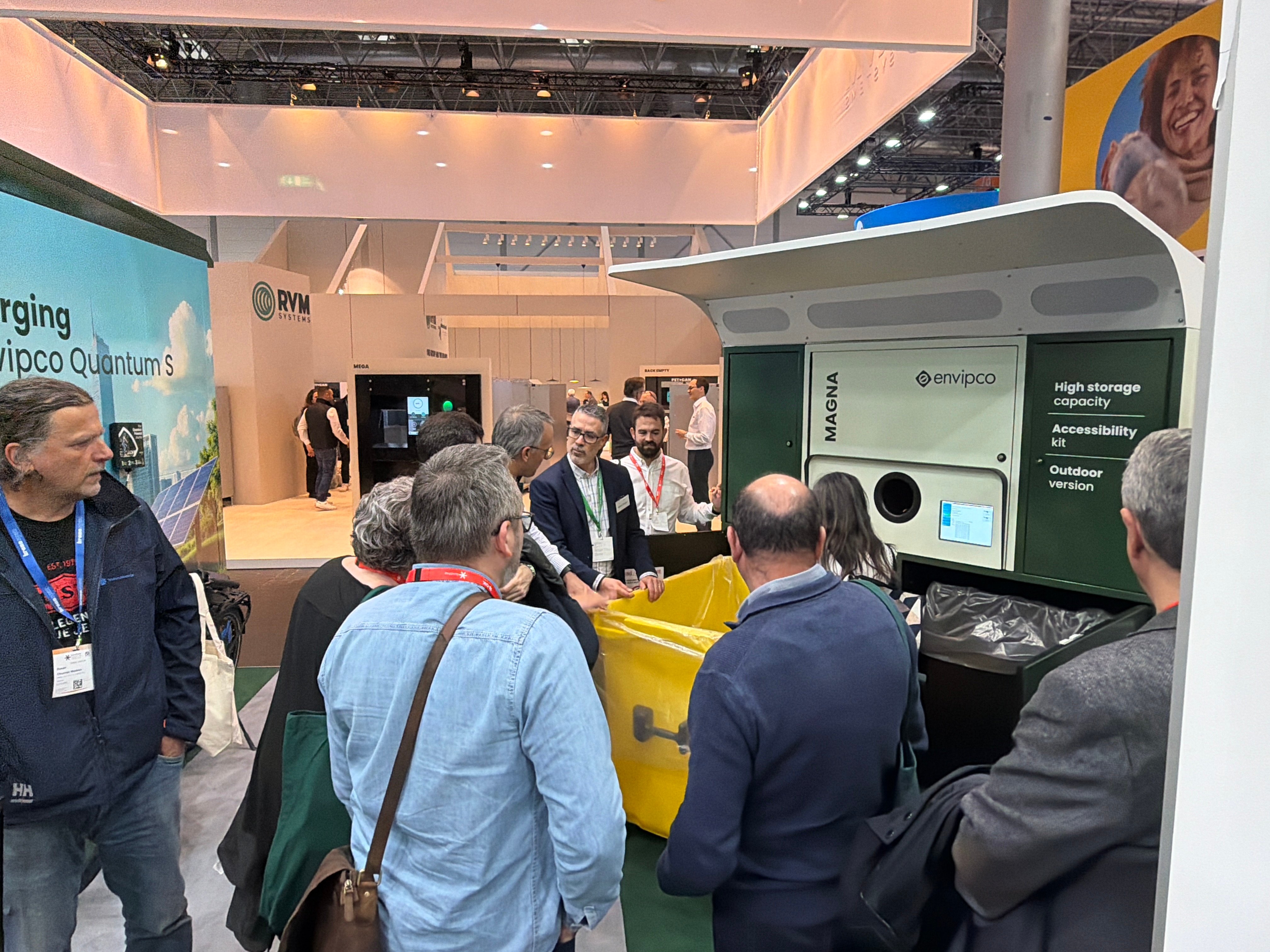 People attentively watching a demonstration of Envipco Magna reverse vending machine